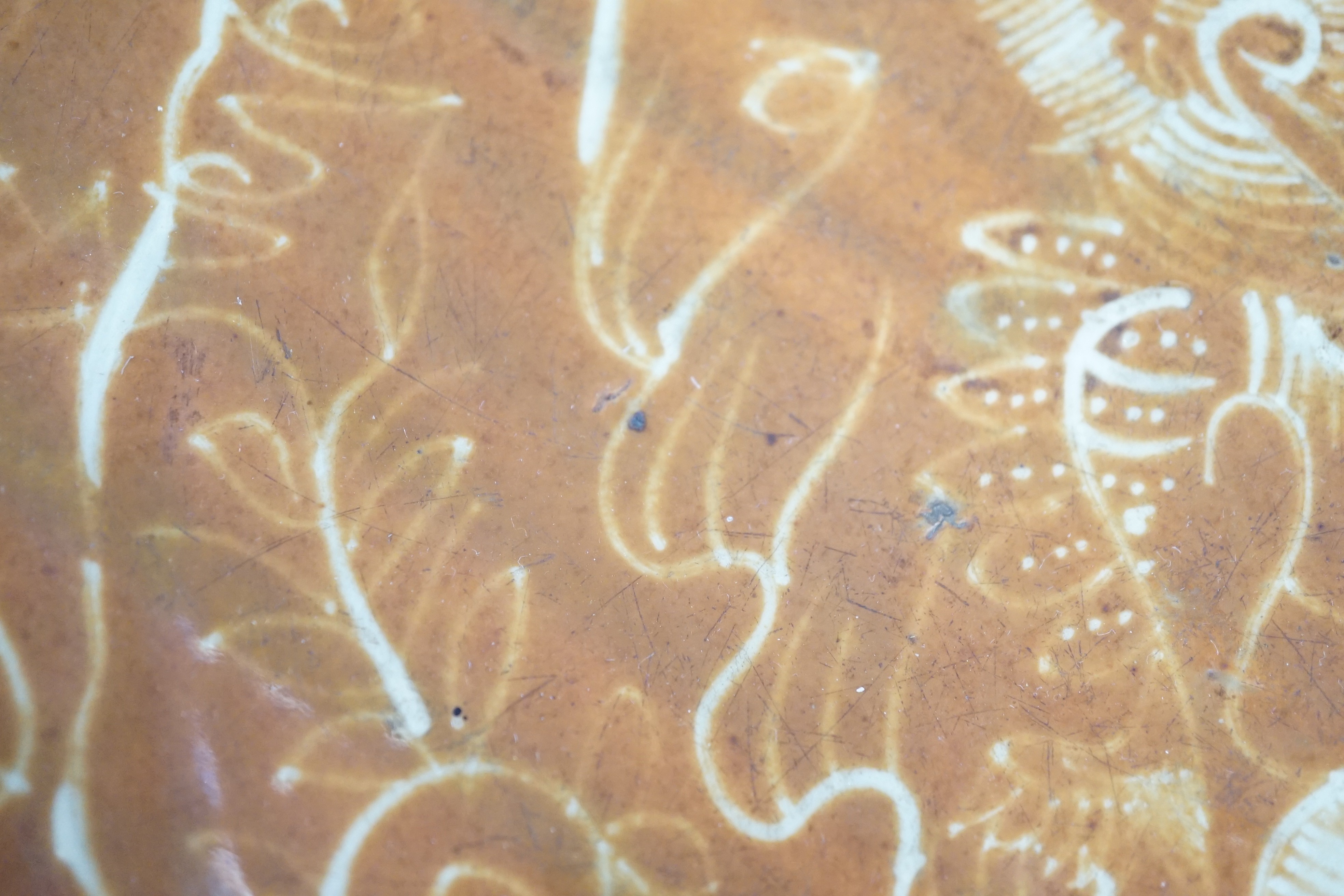 A Chinese Swatow slip-decorated brown ground dish, Zhangzhou kilns, early 17th century, 37cm diameter